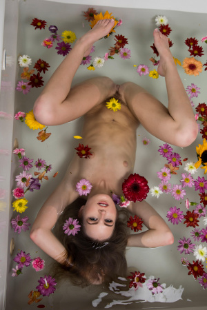 Petite brunette Scarlett Sage masturbating with flowers in the bathroom